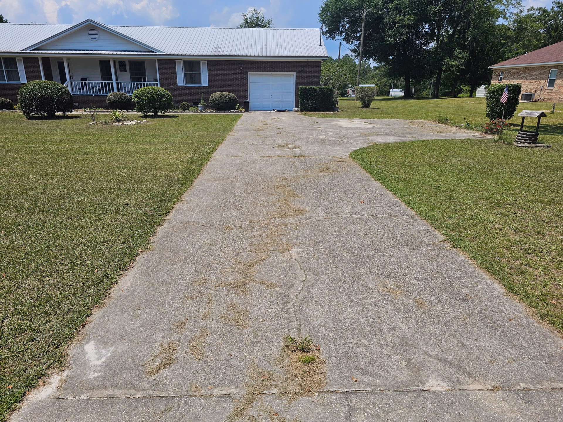 Pressure washed concrete driveway leading to a single-story residential home.