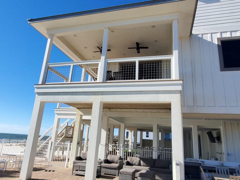 Clean coastal home exterior with upper deck and patio