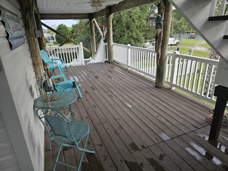 Freshly pressure washed covered wood deck with patio furniture in Crawfordville, FL