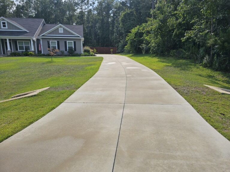 Freshly pressure washed concrete driveway leading to home in Crawfordville, FL