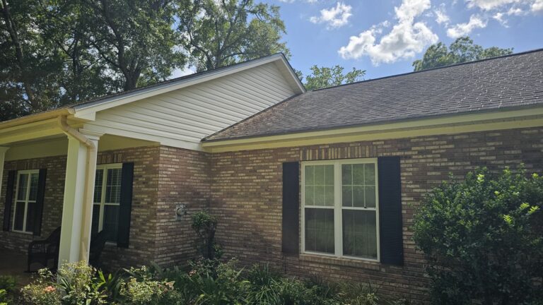 Clean brick home exterior with white siding and gutters in Tallahassee, FL