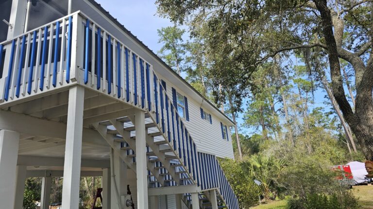 Clean white and blue house exterior after pressure washing in Panacea, FL