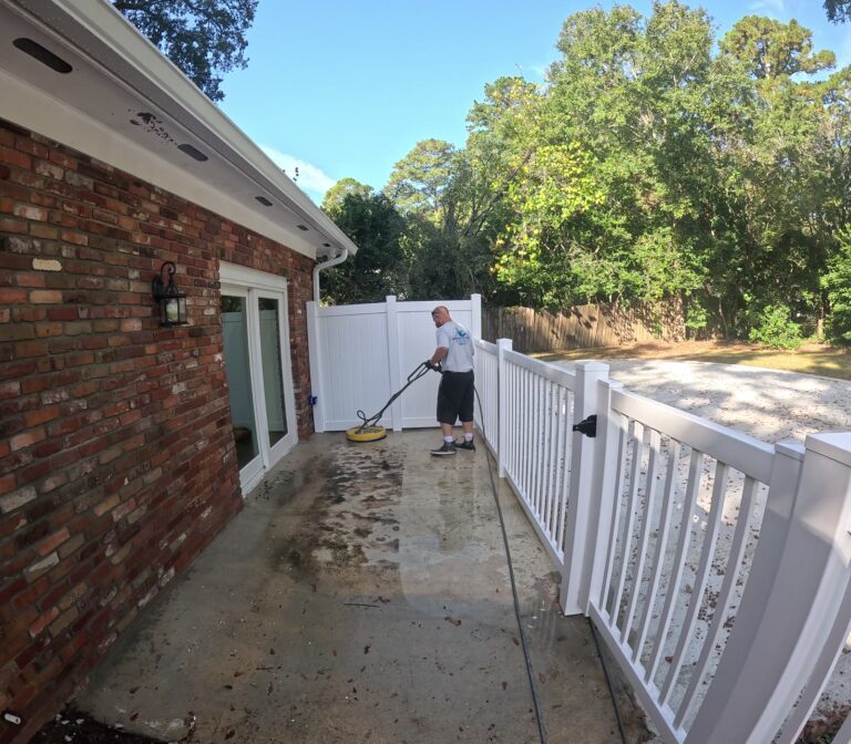 Patio pressure washing in progress beside a white vinyl fence in Killearn Estates, Tallahassee, FL